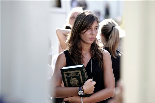 
 A woman holds a copy of the Koran after a meeting with Libyan leader Moammar Gadhafi, at the Libyan Academy near the Libyan ambassador's residence in Rome, Sunday, Aug. 29, 2010 where Gadhafi will be staying. Gadhafi has given a lesson on Islam and copies of the Quran to a few hundred Italian women as he arrived in Rome for his fourth visit in a year, participants in the encounter said. Between 200 and 500 women, recruited by a modeling agency and paid an undisclosed sum to attend, arrived by bus at the Libyan ambassador's residence just as Gadhafi's plane was landing at Rome's Ciampino airport at the start of a two-day visit. (AP Photo/Riccardo De Luca)
 
