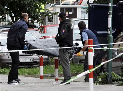
 Slovakian police men remove the body of one of the victims after an unknown man opened fire killing at least six people and wounding many more in Devinska Nova Ves district of Bratislava, Slovakia, Monday, Aug. 30, 2010. (AP Photo/Bela Szandelszky)
 