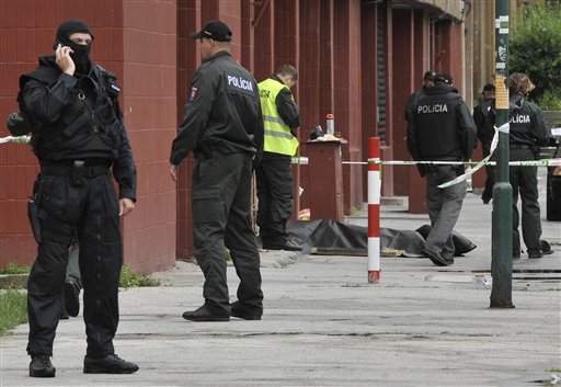 
 Police patrol the scene and a covered body lies on the ground after an unknown man opened fire killing a number of people and wounding more than a dozen people in Bratislava, on Monday, Aug. 30, 2010. The man shot with a scatter-gun and a submachine gun at passers-by and at house windows in a street in Devinska Nova Ves, on Bratislava�s northwestern outskirts. (AP Photo/Bela Szandelszky)
 