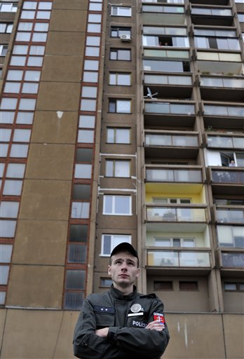 
 A Slovakian police officer stands in front of the building where an unknown man opened fire leaving some people dead and several wounded in Devinska Nova Ves district of Bratislava, Slovakia, Monday, Aug. 30, 2010. (AP Photo/Bela Szandelszky)
 