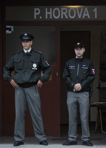 
 Slovakian police officers guard the entrance of the building where an unknown man opened fire leaving several people dead and some wounded in Devinska Nova Ves district of Bratislava, Slovakia, Monday, Aug. 30, 2010. (AP Photo/Bela Szandelszky)
 