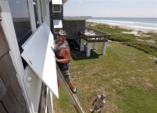 
 Jay Farley, top, installs covers to a homeowner's oceanfront window as Jason Wheeler, bottom, looks on as Hurricane Earl heads toward the eastern coast in Atlantic Beach, N.C., Wednesday, Sept. 1, 2010. (AP Photo/Chuck Burton)
 