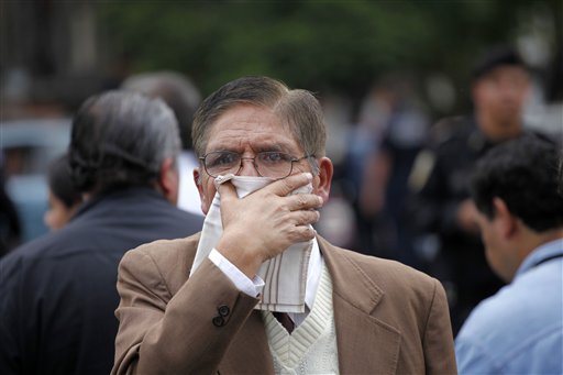 
 A man covers his mouth and nose from the smell as a truck arrives carrying the bodies of some of the 72 migrants who were killed in northern Mexico to a funeral home in Mexico City, Wednesday Sept. 1, 2010. One of two survivors told Mexican investigators that the migrants were detained by people who identified themselves as Zetas, a drug gang that dominates parts of the northern state of Tamaulipas and then killed them when they refused to smuggle drugs. (AP Photo/Eduardo Verdugo)
 