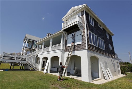 
 Jason Wheeler, top, and Jay Farley, bottom, install protective covers on an oceanfront home as Hurricane Earl heads toward the eastern coast in Atlantic Beach, N.C., Wednesday, Sept. 1, 2010. (AP Photo/Chuck Burton)
 