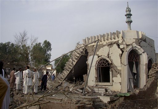 
 People gather at the site of suicide bombing at a police station in Lakki Marwat, Pakistan, Monday, Sept. 6, 2010. A suicide bomber detonated a car in an alley behind a police station in a strategically vital town in northwest Pakistan, killing scores of police and civilians in an explosion that shattered the station and neighboring homes, police said. (AP Photo/G.A. Marwat)
 
