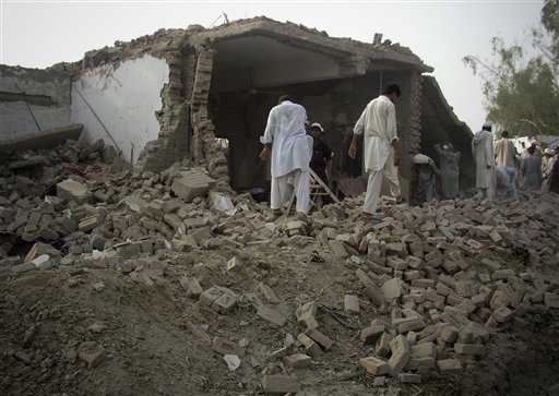 
 People gather at the site of suicide bombing at a police station in Lakki Marwat, Pakistan, Monday, Sept. 6, 2010. A suicide bomber detonated a car in an alley behind a police station in a strategically vital town in northwest Pakistan, killing scores of police and civilians in an explosion that shattered the station and neighboring homes, police said. (AP Photo/G.A. Marwat)
 