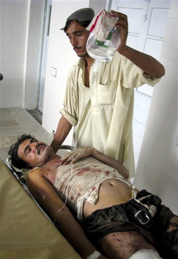 
 A Pakistani stands beside his injured relative, a victim of a suicide bombing, at a local hospital in Bannu, Pakistan on Monday, Sept. 6, 2010. A suicide bomber detonated a car in an alley behind a police station in a strategically vital town in northwest Pakistan, killing scores of police and civilians in an explosion that shattered the station and neighboring homes, police said. (AP Photo/Ijaz Mohammad)
 