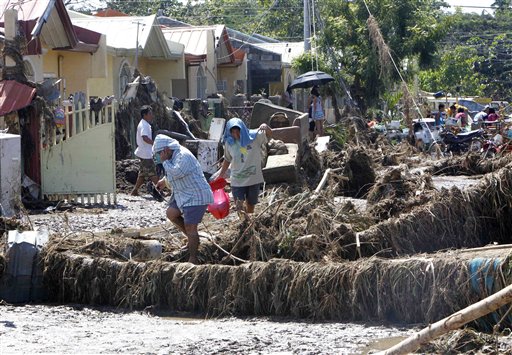 
 A resident rummages through debris following a flash flood that inundated Cagayan de Oro city, Philippines, Saturday, Dec. 17, 2011. A tropical storm triggered flash floods in the southern Philippines, killing scores of people and missing more. Mayor Lawrence Cruz of nearby Iligan said the coast guard and other rescuers were scouring the waters off his coastal city for survivors or bodies that may have been swept to the sea by a swollen river. (AP Photo/Froilan Gallardo)
 