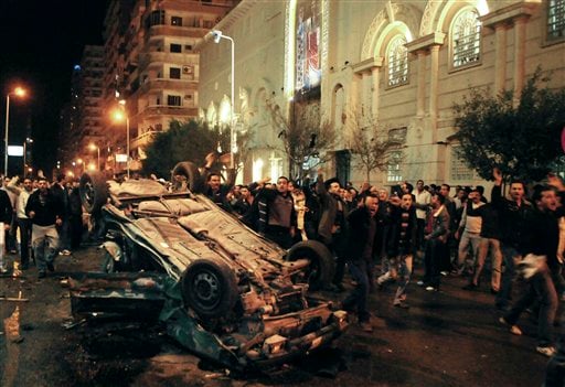 
 Worshippers shout around an exploded car in front of a Coptic Christian church in the Egyptian city of Alexandria, Egypt, early Saturday Jan. 1, 2011. The car exploded in front of the church as worshippers emerged from a New Year's Mass in the Mediterranean port city early Saturday, killing at least seven people, officials said. (AP Photo/Tarek Fawzy)
 