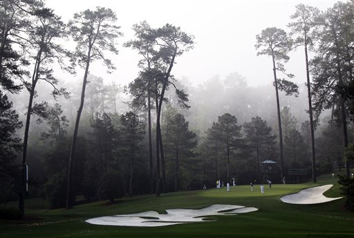 
 Players putt on the 10th green in the morning fog during a practice round for the Masters golf tournament Wednesday, April 4, 2012, in Augusta, Ga. (AP Photo/Chris O'Meara)
 