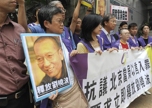 
 Pro-democracy protesters hold the picture of Chinese dissident Liu Xiaobo with Chinese words 'Release Liu Xiaobo' during a demonstration outside the China Liaison Office in Hong Kong Friday, Oct. 8, 2010. Imprisoned Chinese dissident Liu Xiaobo won the 2010 Nobel Peace Prize on Friday for using non-violence to demand fundamental human rights in his homeland. (AP Photo/Apple Daily) ** HONG KONG OUT, NO SALES **
 