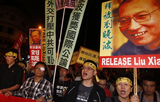 
 Pro-democracy protesters hold the picture of Chinese dissident Liu Xiaobo with Chinese words 'Release Liu Xiaobo' during a demonstration outside the China's Liaison Office in Hong Kong Friday, Oct. 8, 2010. Imprisoned Chinese dissident Liu Xiaobo won the 2010 Nobel Peace Prize on Friday for using non-violence to demand fundamental human rights in his homeland. (AP Photo/Kin Cheung)
 
