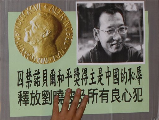 
 A pro-democracy protester holds the picture of Chinese dissident Liu Xiaobo with Chinese words ''Imprison the Nobel Peace Prize winner is Chinese shame' and 'Release Liu Xiaobo and all dissidents' during a demonstration outside the China's Liaison Office in Hong Kong, Friday, Oct. 8, 2010. Imprisoned Chinese dissident Liu Xiaobo won the 2010 Nobel Peace Prize on Friday for using non-violence to demand fundamental human rights in his homeland. (AP Photo/Kin Cheung)
 