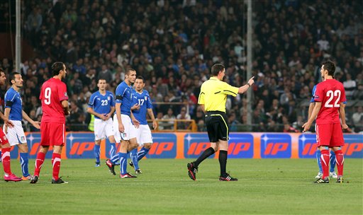 
 Scottish referee Craig Thomson, center with yellow jersey, talks to Italy and Serbia players while the Group C, Euro 2012 qualifying soccer match between Italy and Serbia is suspended, at the Luigi Ferraris stadium in Genoa, Italy, Tuesday, Oct. 12, 2010. The Italy-Serbia European Championship qualifier was called off after seven minutes of play on Tuesday after Serbia fans threw flares and fireworks onto the pitch. (AP Photo/Carlo Baroncini)
 