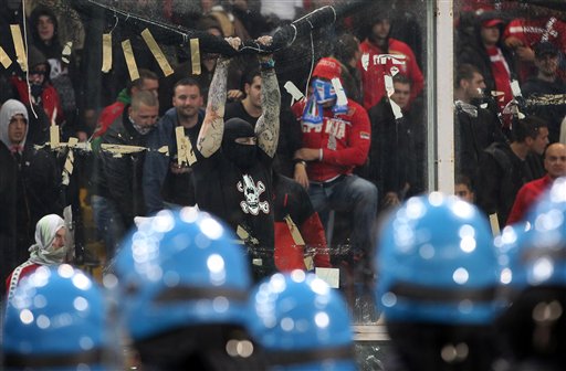 
 Serbia fans challenge Italian police prior to the start of a Group C, Euro 2012 qualifying soccer match between Italy and Serbia, at the Luigi Ferraris stadium in Genoa, Italy, Tuesday, Oct. 12, 2010. The start of the Italy-Serbia European Championship qualifier has been delayed due to Serbia fans throwing flares onto the pitch and lighting fireworks. (AP Photo/Carlo Baroncini)
 