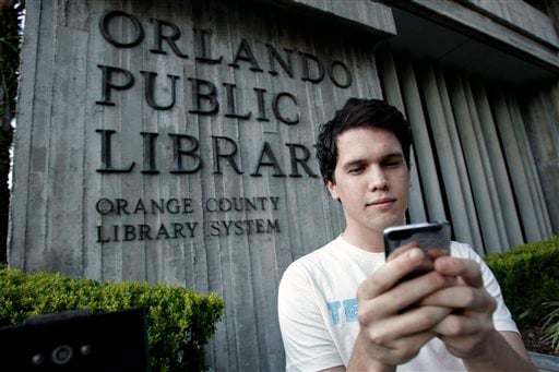 
 Hillard Goodspeed uses an ipod application called 'shake it', to find reading suggestions at the Orlando Public Library in Orlando, Fla., Wednesday, Sept. 1, 2010.(AP Photo/John Raoux)
 