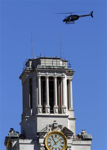 
 A police helicopter flies over the University of Texas clock tower as the campus is searched after a gunman opened fire then killed himself inside a library, Tuesday, Sept. 28, 2010 in Austin. (AP Photo/Eric Gay)
 