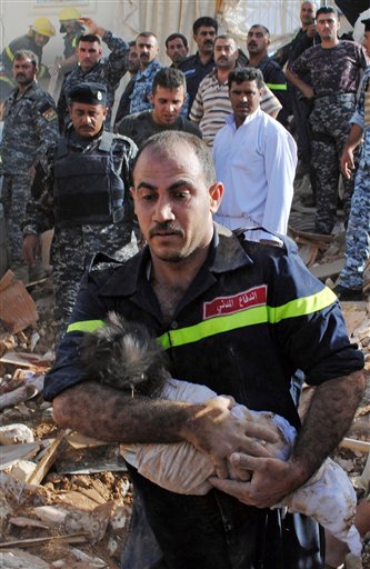 
 ** CORRECTS GENDER OF CHILD IN SECOND SENTENCE ** An Iraqi emergency worker carries the lifeless body of 6-month-old Shahad Mohammed from the bombed out ruins of his home in Tikrit, 80 miles (130 kilometers) north of Baghdad, Iraq, Tuesday, Oct. 19, 2010. Iraqi officials say a bomb has detonated near the house of a police officer in Saddam Hussein's hometown of Tikrit, killing his 6-month-old niece and several other family members of teh polcie officer. Police and hospital officials say the officer, Lt. Col. Qais Rashid, was unharmed in Tuesday's blast, but his brother, sister and sister-in-law were killed along with his baby niece Shahad Mohammed, Col. Khalid Jassim of Tikrit police said.(AP Photo/Bassim Daham)
 