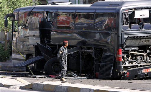 
 An Iraqi policeman inspects a destroyed bus in Baghdad, Iraq, Tuesday, Oct. 19. 2010. Two bombs attached to buses carrying Iranian pilgrims detonated while they drove through downtown, police said. (AP Photo/Hadi Mizban)
 