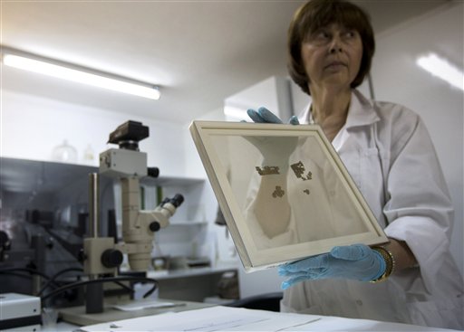 
 Lena Libman, a worker of the Dead Sea Scrolls conservation laboratory at the IAA, Israel Antiquities Authority, holds a frame with small fragments of the Dead Sea Scrolls in a laboratory in Jerusalem, Tuesday, Oct. 19, 2010. Israel's Antiquities Authority and Google announced Tuesday they are joining forces to bring the Dead Sea Scrolls online, allowing both scholars and the general public widespread access to the ancient manuscripts for the first time. (AP Photo/Sebastian Scheiner)
 