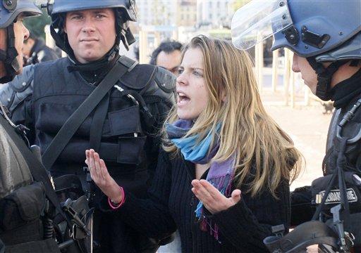 
 A woman argues with police forces in Lyon, central France, Thursday Oct. 21, 2010. Youths overturned a car and hurled bottles at police in the French city of Lyon amid nationwide tensions over raising the retirement age. Police are chasing the protesters and trying to subdue the violence with tear gas. (AP Photo/Michel Spingler)
 