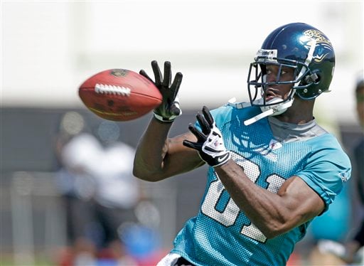 
 FILE - This June 8, 2010, file photo shows Jacksonville Jaguars wide receiver Kassim Osgood catching a pass during football workouts in Jacksonville, Fla. Osgood leapt out a second-floor window to escape a gun-wielding man who attacked him and a 19-year-old woman. According to the Jacksonville Sheriff's Office, the armed intruder exchanged gunfire with his ex-girlfriend, Mackenzie Rae Putnal, after putting a gun to her head on Monday night, Sept. 27, 2010. (AP Photo/John Raoux, File)
 