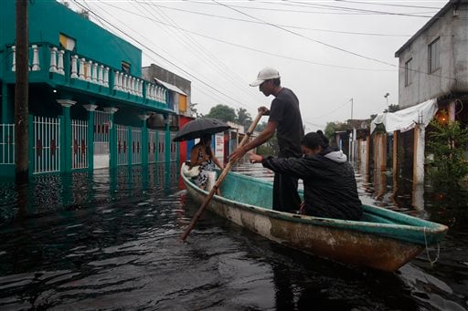 
 People use a boat to cross a flooded street in the town of Centla in the state of Tabasco, Mexico, Wednesday Sept. 29, 2010. The area has been battered by the remnants of a hurricane and a tropical storm that followed. (AP Photo/America Rocio)
 
