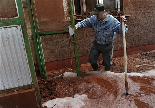 
 Logs carried in by the flooding toxic mud cover a yard in the town of Devecser, Hungary, Tuesday, Oct. 5, 2010. Monday's flooding was caused by the rupture of a red sludge reservoir at an alumina plant in western Hungary and has affected seven towns near the Ajkai Timfoldgyar plant in the town of Ajka, 100 miles (160 kilometers) southwest of Budapest. (AP Photo/Bela Szandelszky)
 
