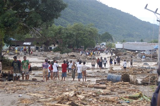 
 Residents gather to inspect the damage suffered by an area affected by a flash flood in Wasior, Papua province, Indonesia, Tuesday, Oct. 5, 2010. Heavy rain unleashed flash floods and mudslides, killing dozens of people in a remote corner of the country that rescuers were still struggling to reach days after the storms began, officials and witnesses said Tuesday. (AP Photo/Abdul Muin)
 