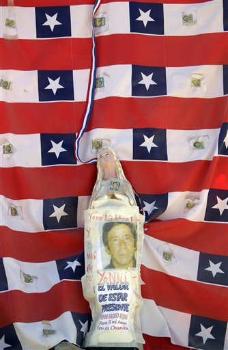 
 A statue to the Virgin Mary is covered with a photo of Yonny Barrios, one of 33 miners trapped in the collapsed San Jose mine, at the camp where relatives wait for news outside the mine in Copiapo, Chile, Wednesday Oct. 6, 2010. Thirty-three miners have been trapped deep underground in the copper and gold mine since it collapsed on Aug. 5. (AP Photo/Natacha Pisarenko)
 