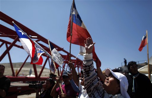 
 Volunteer missionary Aurelia Navarro makes the sign of the cross as a giant crane arrives to be used in the rescue operation of 33 trapped miners at the San Jose mine near Copiapo, Chile, Wednesday Oct. 6, 2010. Thirty-three miners have been trapped deep underground in the copper and gold mine since it collapsed on Aug. 5. (AP Photo/Natacha Pisarenko)
 