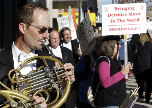 
 Detroit Symphony Orchestra member Karl Pituch plays his French horn as he serenades fellow members walking a picket line outside the Max M. Fisher Music Center in Detroit, Monday, Oct. 4, 2010. Musicians have called a strike after refusing to accept pay cuts of more than 30 percent demanded by the financially struggling Detroit Symphony Orchestra. (AP Photo/Paul Sancya)
 