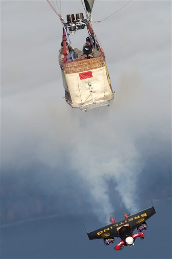 
 Swiss pilot Yves Rossy, the first man in the world to fly under a jet-fitted wing, speeds through the air to perform a looping near a hot air balloon in Bercher, western Switzerland, Friday, Nov. 5, 2010. (AP Photo/Keystone, pool, Laurent Gillieron)
 