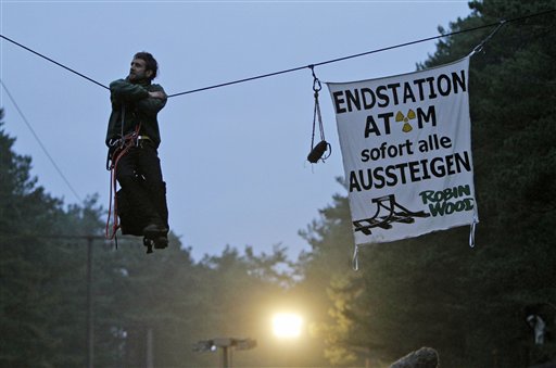 
 A Robin wood activist hangs on a rope crossing a road close to the nuclear interim storage facility in Gorleben, Germany, Tuesday, Nov. 9, 2010. A shipment of nuclear waste from France made it to a storage facility in northwestern Germany on Tuesday, after police worked through the night to clear a road blockade by more-than 3,000 protesters. Banner reads 'Final Stop, Atom, all get off immediately'. (AP Photo/Ferdinand Ostrop)
 