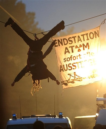 
 An activist of the environmental organization Robin Wood hangs from a rope that was fixed between two trees during a protest against the nuclear waste transport in Gorleben, northern Germany Tuesday Nov. 9, 2010. Trucks carrying 123 tons of nuclear waste have finally reached the storage facility in Gorleben after police worked through the night to clear thousands of protesters blockading the roads. Banner reads 'Final Stop, Atom, all get off immediately'. (AP Photo/dapd, Thomas Lohnes)
 