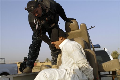 
 An Iraqi policeman adjusts the blindfold on a suspected terrorist during a joint operation in al-Shaheed village in Kirkuk province, north of Baghdad, Iraq, Wednesday, Nov. 10, 2010. The man was detained during a sweep by Iraqi police and Iraqi Army soldiers of several villages thought to be insurgent havens. U.S. troops were on hand to advise and assist if necessary. (AP Photo/Maya Alleruzzo)
 