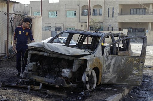 
 An Iraqi man inspects his destroyed car at the scene of a bomb attack in Baghdad, Iraq, Wednesday, Nov. 10, 2010. A string of bombings targeted Christian houses in Baghdad early Wednesday, killing and wounding several people, police said. (AP Photo/Khalid Mohammed)
 