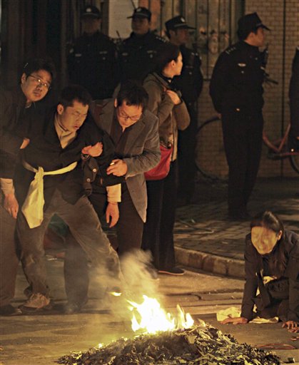 
 Chinese police officers stand watch the relatives mourn for victims who has killed in the Monday fire on an apartment building in Shanghai, China Tuesday Nov. 16, 2010. Police detained unlicensed welders Tuesday for accidentally starting a fire that engulfed the high-rise apartment building under renovation in China's business capital that killed at least 53 as public anger grew over the government's handling of the disaster. (AP Photo) ** CHINA OUT **
 