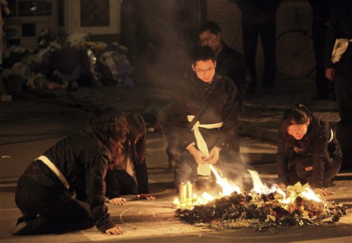 
 Relatives burn the belongings of their relatives who were killed in the Monday fire on an apartment building in Shanghai, China Tuesday Nov. 16, 2010. Police detained unlicensed welders Tuesday for accidentally starting a fire that engulfed the high-rise apartment building under renovation in China's business capital that killed at least 53 as public anger grew over the government's handling of the disaster. (AP Photo) ** CHINA OUT **
 