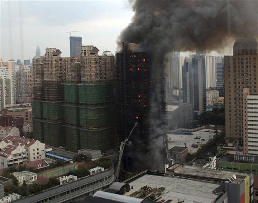 
 Firefighters spray water on an apartment building on fire in the downtown area of Shanghai, east China, on Monday Nov. 15, 2010. The state news agency says the fire in the high-rise apartment building in China's business center of Shanghai has killed at least eight people and injured more than 90. (AP Photo/Color China Photo)**CHINA OUT**
 