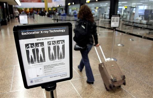 
 FILE - In this Nov. 19, 2010 file photo, a passenger walks past a sign informing travelers about the use of full-body scanners for TSA security screening at Seattle-Tacoma International Airport in Seattle. The TSA has demonstrated a knack for ignoring the basics of customer relations, while struggling with what experts say is an all but impossible task. It must stand as the last line against unknown terror, yet somehow do so without treating everyone from frequent business travelers to the family heading home to visit grandma as a potential terrorist. (AP Photo/Ted S. Warren, File)
 