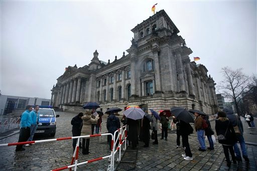 
 Visitors stand at a security fence in front of the Reichstag building, Germany's house of parliament, in Berlin on Monday, Nov. 22, 2010. After Germany's Interior Ministry raised the country's terrorist threat level last week, Germany's parliament said it is closing down the cupola of the Reichstag building to visitors over security concerns. (AP Photo/Markus Schreiber)
 