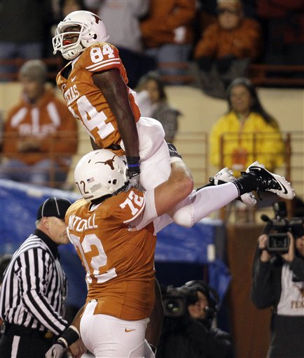 
 Texas' Marquise Goodwin (84) is hoisted in the air by teammate Britt Mitchell after scoring a touchdown against Texas A&M during the first quarter of an NCAA college football game, Thursday, Nov. 25, 2010, in Austin, Texas. (AP Photo/Eric Gay)
 