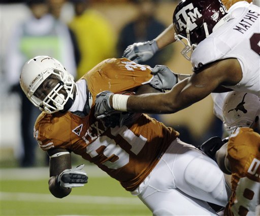 
 Texas' Cody Johnson (31) is brought down by Texas A&M's Jonathan Mathis, right, during the third quarter of an NCAA college football game, Thursday, Nov. 25, 2010, in Austin, Texas. (AP Photo/Eric Gay)
 