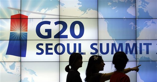 
 Women walk by a screen showing G20 Seoul Summit sign at the venue for the upcoming summit meeting, scheduled on Nov. 11-12, in Seoul, South Korea, Tuesday, Nov. 2, 2010. (AP Photo/ Lee Jin-man)
 