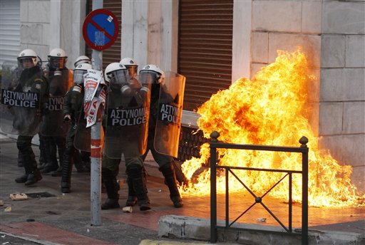 
 Riot police try to avoid a petrol bomb outside a luxury hotel during clashes in Athens, Wednesday, Dec. 15, 2010. Hundreds of protesters clashed with riot police across central Athens Wednesday, smashing cars and hurling gasoline bombs during a massive labor protest against the government's austerity measures. Wednesday's violence occurred after some 20,000 protesters marched to parliament during a general strike against a new round of labor reforms in the crisis-hit country. (AP Photo/Thanassis Stavrakis)
 