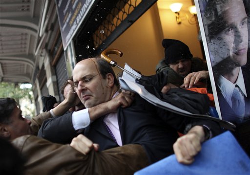 
 Former Greek development minister Costis Hatzidakis, center, is attacked by protesters in Athens, Wednesday, Dec. 15, 2010. Protesters clashed with riot police across Athens on Wednesday, torching cars, hurling gasoline bombs and sending Christmas shoppers fleeing in panic during a general strike against the government's latest austerity measures. (AP Photo)
 