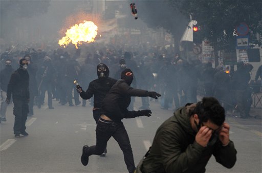 
 Protesters throw petrol bombs during clashes in Athens, Wednesday, Dec. 15, 2010. Hundreds of protesters clashed with riot police across central Athens Wednesday, smashing cars and hurling gasoline bombs during a massive labor protest against the government's austerity measures. Wednesday's violence occurred after some 20,000 protesters marched to parliament during a general strike against a new round of labor reforms in the crisis-hit country. (AP Photo/Alkis Konstantinidis)
 