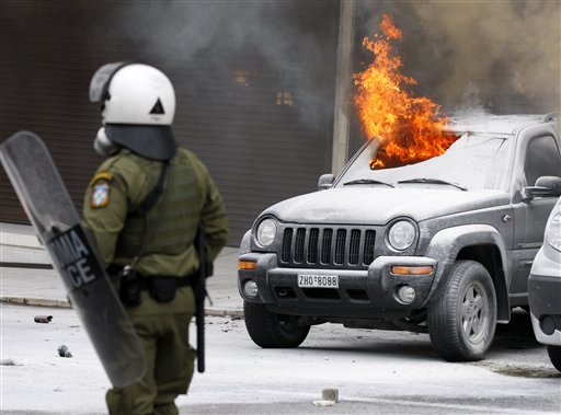 
 A jeep burns outside a luxury hotel during clashes in Athens, Wednesday, Dec. 15, 2010. Hundreds of protesters clashed with riot police across central Athens Wednesday, smashing cars and hurling gasoline bombs during a massive labor protest against the government's austerity measures. Wednesday's violence occurred after some 20,000 protesters marched to parliament during a general strike against a new round of labor reforms in the crisis-hit country. (AP Photo/Thanassis Stavrakis)
 