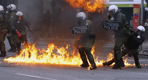
 Riot police tries to avoid a petrol bomb during clashes in Athens, Wednesday, Dec. 15, 2010. Hundreds of protesters clashed with riot police across central Athens Wednesday, smashing cars and hurling gasoline bombs during a massive labor protest against the government's austerity measures. Wednesday's violence occurred after some 20,000 protesters marched to parliament during a general strike against a new round of labor reforms in the crisis-hit country. (AP Photo/Thanassis Stavrakis)
 